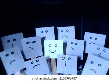 The concept drawing positive influence notepad is picture happy face emoji among various bad sad emoji faces  