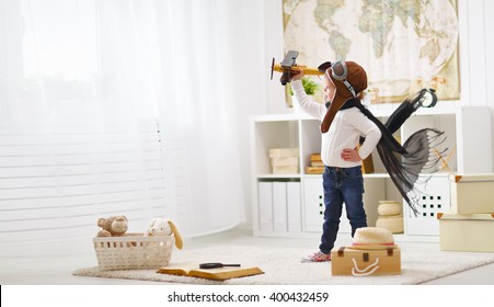 concept of  dreams and travels.  pilot aviator child with a toy airplane plays at home in his room