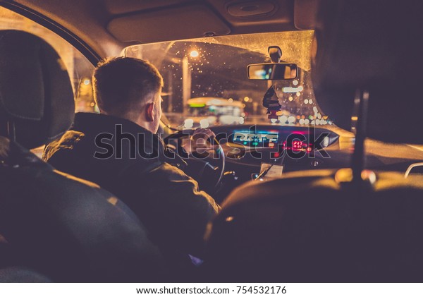 Concept of driving a car at night -man driving his\
modern car at night in a\
city