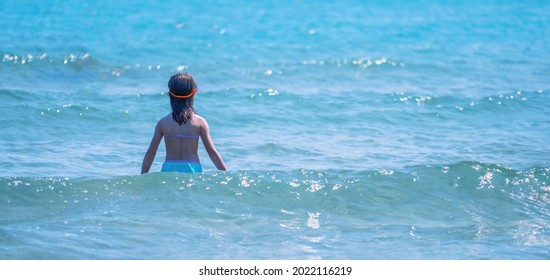 Concept: Drowning Dangers For Kids And Outdoor Water Safety For Parents. Beautiful Young Girl Swims Alone In The Sea. Copy Space.