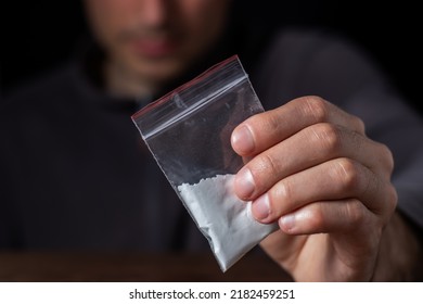 Concept Drug Addiction. Man Hand Holds Plastic Packet Or Bag With Cocaine Or Another Drugs, Drug Abuse And Danger Addiction Concept.