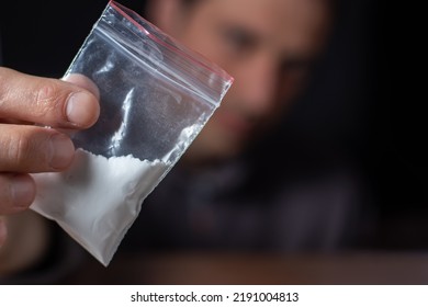 Concept Drug Addiction. Man Hand Holds Plastic Packet Or Bag With Cocaine Or Another Drugs, Drug Abuse And Danger Addiction Concept.