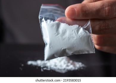 Concept Drug Addiction. Man Hand Holds Plastic Packet Or Bag With Cocaine Or Another Drugs, Drug Abuse And Danger Addiction Concept.