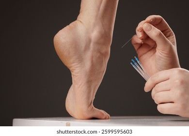 concept dry needling method, Acupuncture therapy on the foot, close-up of a practitioner's hands inserting thin needles into the heel for pain relief and alternative medicine.