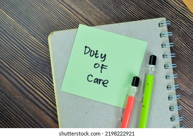 Concept of Duty of Care write on sticky notes isolated on Wooden Table. - Shutterstock ID 2198222921