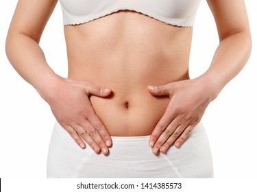 Concept of early term of pregnancy. Close up photo of woman's abdomen and belly button, she is touching her slim stomach with two hands. isolated on white background