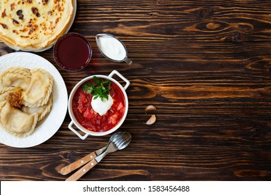 The Concept Of Eastern European National Cuisine. Ukrainian, Russian, Polish Food.Traditional Beetroot Soup Borscht With Sour Cream, Pancakes Blini, Dumplings Vareniki With Potatoes And Fried Onions