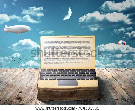 The concept of e-book. An open book as laptop lies on a wooden table against the sky. Writing.
