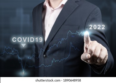 Concept Of Economic Recovery After The Fall Due To The Covid 19 Coronavirus Pandemic. 2022 Year. Financial Graph. Businessman Pointing Graph Future Growth Plan On Dark Blue