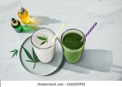 Concept edibles CBD and drinks with cannabis . Glasses with fresh beverage, milk and smoothies, with hemp. Flat lay