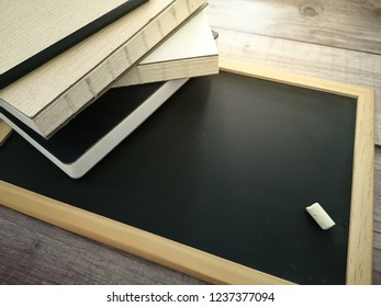 Concept of education with stack of books and pencil on blackboard