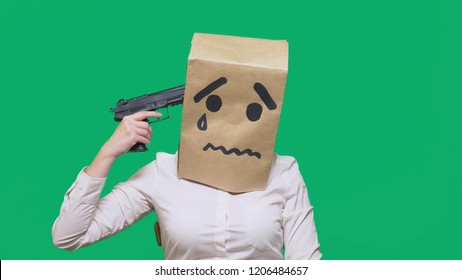 concept of emotion, gestures. a man with a package on his head, with a painted smiley, exhausted, tired, Holds a gun in his hand. The concept of suicide.