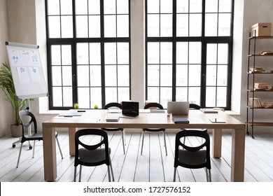 Concept Of Empty Modern Loft Office Space With Wooden Table In Boardroom. Electronic Laptop Appliances Ready For Meeting. Working Workplace With No People Prepared For Briefing Whiteboard Presentation