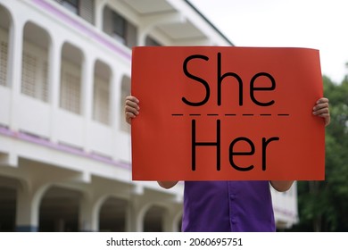 Concept : English grammar, subject and object pronouns teaching. Word " She- Her" on red paper sign held by a student at school. Word card for education. Teaching material. Personal pronouns. - Shutterstock ID 2060695751