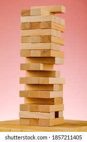 The Concept Of Entrepreneurial Risk With The Jenga Model. Wooden Blocks On A Pink Background