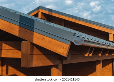 The Concept Of Environmentally Friendly Housing. Part Of The Roof Of A Wooden House In A Modern Style Against A Blue Cloudy Sky.