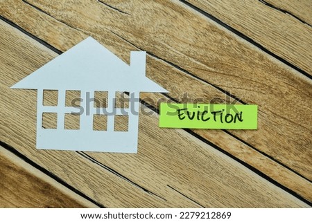 Concept of Eviction write on sticky notes isolated on Wooden Table.