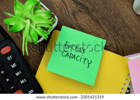 Concept of Excess Capacity write on sticky notes isolated on Wooden Table.