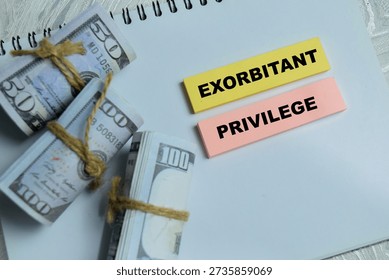 Concept of exorbitant privilege write on sticky notes isolated on Wooden Table. Representing global economics advantage of the United States