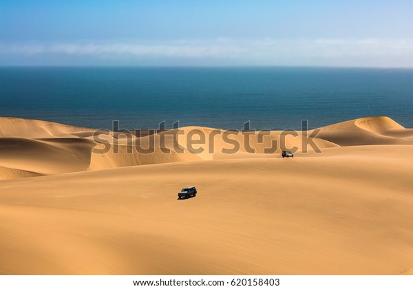 The concept of exotic and extreme travel.\
Magical jeep - safari through the sand dunes on the ocean coast.\
Atlantic shore of Namibia, south of\
Africa