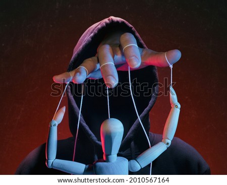 The concept of extortion, blackmail. Man in a hoodie and a puppet. [[stock_photo]] © 