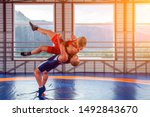 The concept of fair wrestling. Two greco-roman  wrestlers in red and blue uniform making a suplex wrestling  on a wrestling carpet in the gym.The concept of male wrestling and resistance