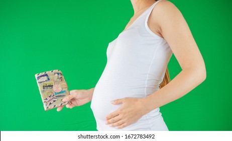 Concept Of A Family And Expectation As A Pregnant Woman Is Holding A Travel Document, Passport Next To Her Belly Expecting A New Chapter Of Her Life With The New Baby