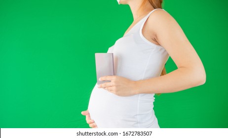 Concept Of A Family And Expectation As A Pregnant Woman Is Holding A Travel Document, Passport Next To Her Belly Expecting A New Chapter Of Her Life With The New Baby