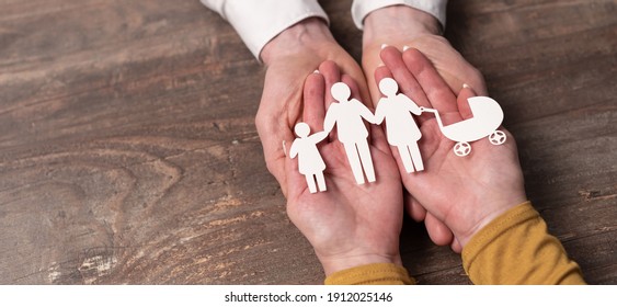 Concept of family insurance with paper family in hands
