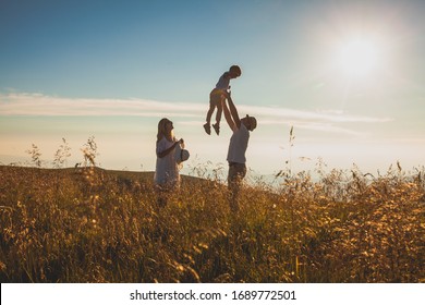 The concept of family and love. Parents with their son in summer field