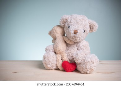 Concept family, love, and valentines festival. Big and little brown teddy bears sitting huggy show love, happiness on an old wooden table with copy space.