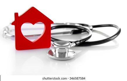 Concept of family medicine - red plastic house and stethoscope isolated on white background