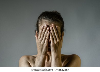 Concept Of Fear, Shame, Domestic Violence. Woman Covers Her Face Her Hands On Scratched Background.