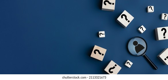 Concept of finding a creative idea or solving a problem. Question mark on wooden cubes and a magnifying glass with a human icon on a blue background