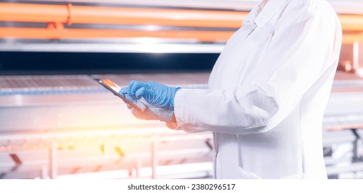 Concept food industry banner. Factory worker inspecting production line tanker in of dairy factory with computer tablet - Shutterstock ID 2380296517
