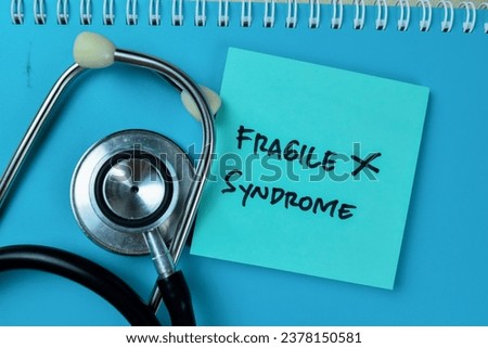 Concept of Fragile X Syndrome write on sticky notes isolated on Wooden Table.