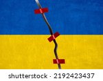 The concept of the fragmentation of the country, separatism and efforts to preserve the integrity of the state. Cracked concrete background with a painted Ukrainian flag, fastened with red sticky tape