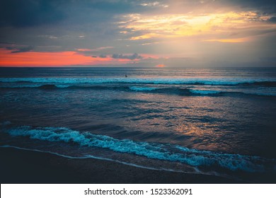 Concept freedom beach background - sunset or sunrise on the ocean horizon with waves at the night dramatic sky