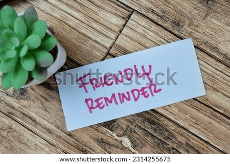 Concept of Friendly Reminder write on sticky notes isolated on Wooden Table.