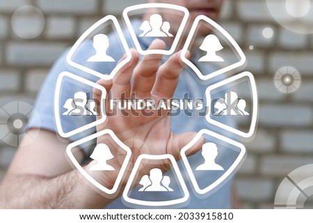 Concept of fundraising. Fundraiser using virtual touchscreen clicks a fundraising word.