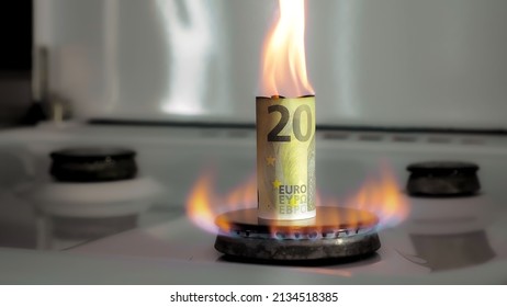 Concept of gas crisis. 20 euro bill is burning on a kitchen stove burner. European cash money. High prices of natural resources. Fire flame. Utility debt. Energy war. Saving home budget. Finance.