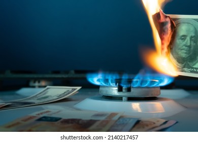 Concept of gas crisis. Burning Banknote on the background of a gas burner.Cash. High prices for natural resources. Tongues of flame. Public debt. Energy war.Out of focus.