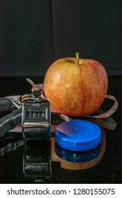 Concept - Getting in Shape. Closeup on Measuring Tape, Click counter and Apple