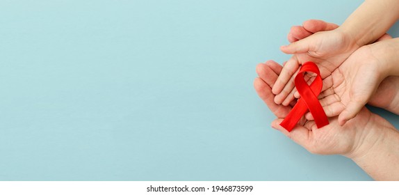 Concept Of Give Blood Transfusion And Donation. Hands Of Mother And Child Holding Red Ribbon On Blue Background. Hemophilia Day. World Health Day. Layout. Copy Space. Banner. Mock Up