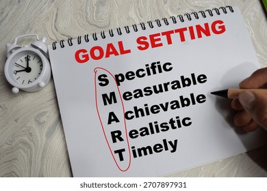 Concept of goal setting and smart write on book isolated on Wooden Table.