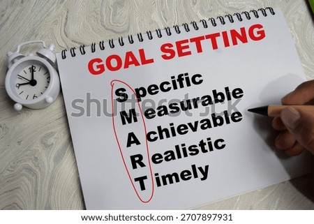 Concept of goal setting and smart write on book isolated on Wooden Table.