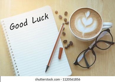 Concept Good Luck Message On Notebook With Glasses, Pencil And Coffee Cup On Wooden Table.  Sunlight In The Morning.