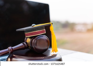 Concept of graduate online study international abroad about jurisprudence laws certificate in university distance education for learning. Graduation diploma hat / Judge gavel on computer notebook.