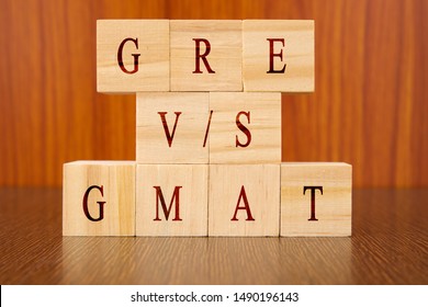 Concept Of GRE Vs GMAT Exam Differences In Wooden Block Letters On Table