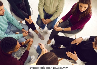 Concept of group therapy meeting, talking about and dealing with psychological problems, getting help and support. High angle of diverse people sitting in circle listening to man sharing his concerns - Powered by Shutterstock